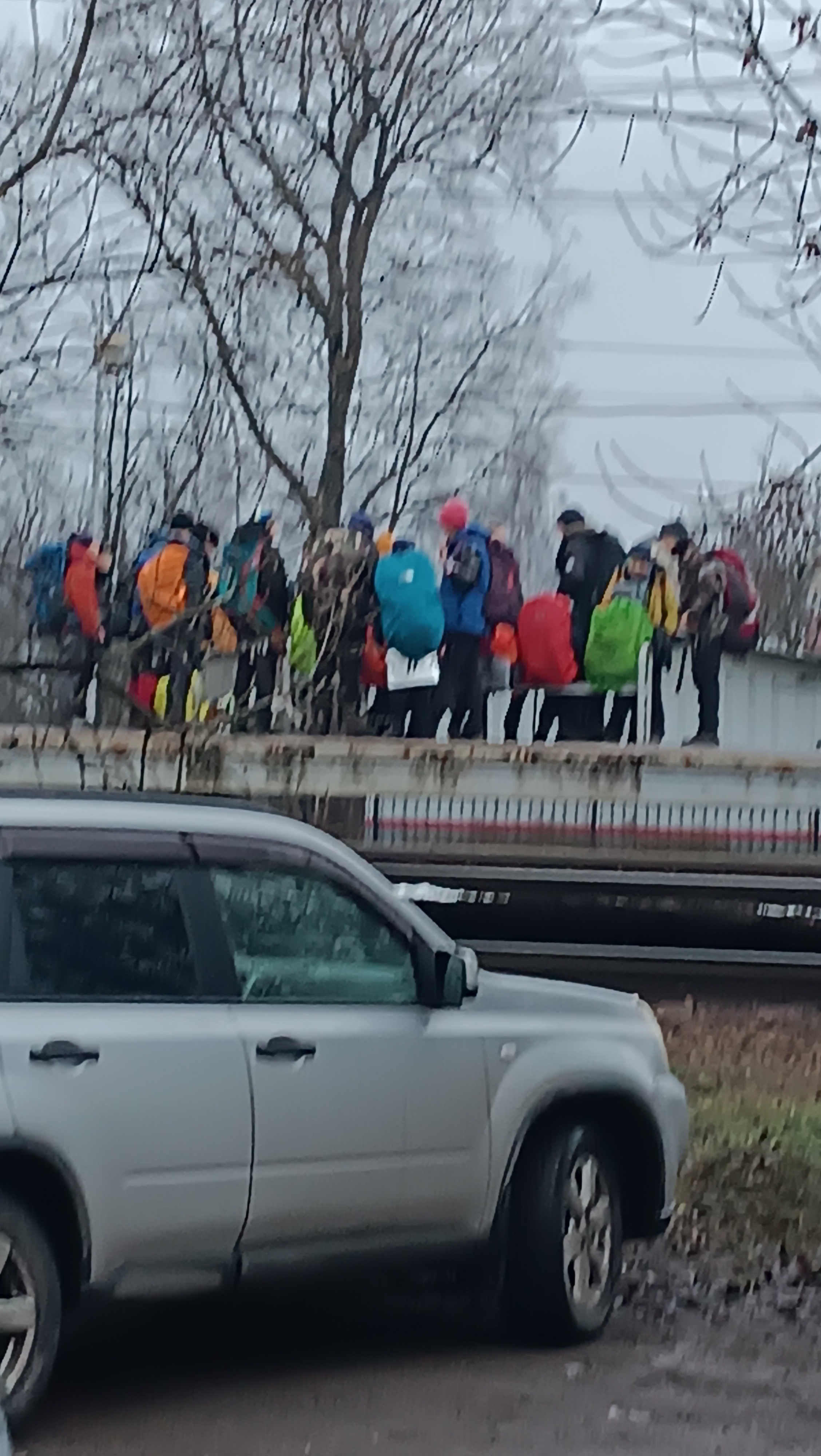 Дети на платформе ждут электричку в разноцветной одежде, уничтожающей 